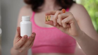 Sağlığın ve genel sağlığın önemini vurgulayan bir şişe vitamini elinde tutan bir kadın.