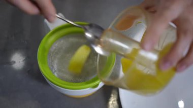 Yetenekli bir el sağlıklı bir yemek yapmak için canlı ananas parçaları hazırlar.