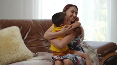 Sevgi dolu bir annenin parlak, davetkar bir oturma odasında çocuğunu kucakladığı inanılmaz dokunaklı bir sahne.