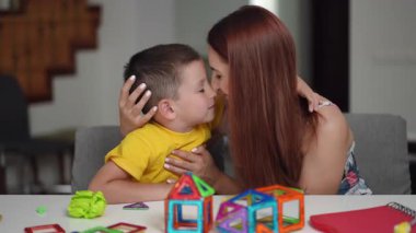 Neşeli bir anne ve oğlu birlikte güzel vakit geçiriyorlar. Renkli oyuncaklarla kalıcı anılar yaratıyorlar.