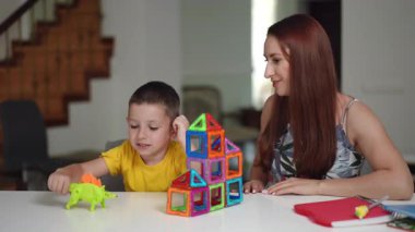 Neşeli bir öğrenme anı başlıyor. Bir çocuk hevesle, renkli ve canlı oyuncaklarla oynuyor. Yetişkin birinin yanında.