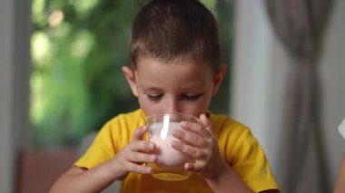 Parlak sarı tişörtlü neşeli bir çocuk sıcak, sevgi dolu bir evde eğlenceli aktiviteler yapar.