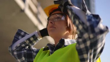 Kendini işine adamış bir inşaat işçisi, inşaat alanında gerekli güvenlik teçhizatlarıyla güne hazırlanıyor.