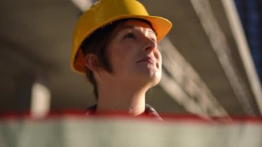 Güvenlik donanımı giymiş, özveri, uzmanlık ve paha biçilemez inşaat yeteneklerini sergileyen kendine güvenen bir işçi.