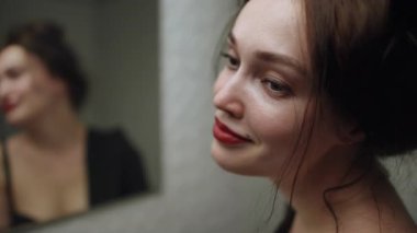 Bir kadın aynanın karşısında hazırlanır, derin bir duygu ve güzelliği kısa bir an içinde yakalar.