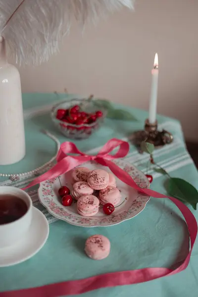 pink macarons served with cherries