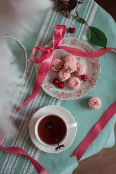 pink macarons served with cherries