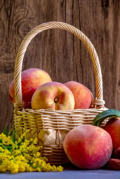 Light tan wicker basket, holds a ripe, juicy peaches at summers end in Michigan USA