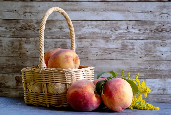 Rustic still life with a light tan basket and fresh peaches