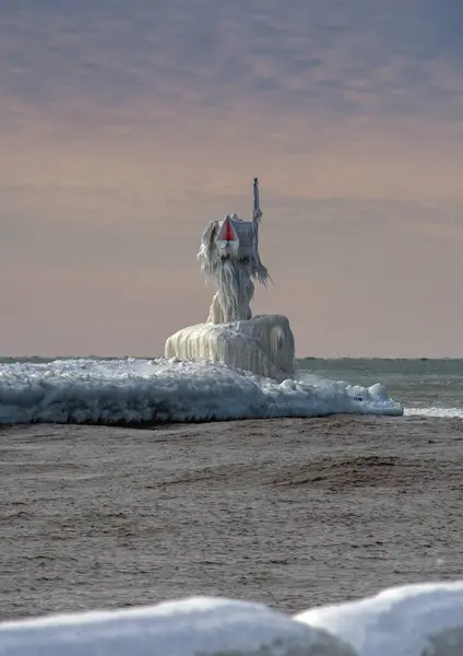 密执安州圣约瑟夫市北部码头的灯塔上布满了冰 看起来像密歇根湖畔一座漂亮的冰冻雕塑 免版税图库图片