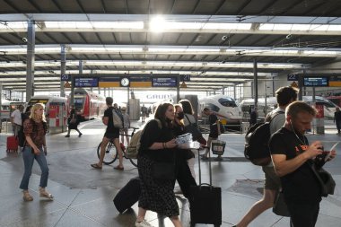 25 Temmuz 2022 'de Almanya' daki Münih Merkez İstasyonu 'na bir banliyö treni geldikten sonra bir platformda yürüyen yolcu..