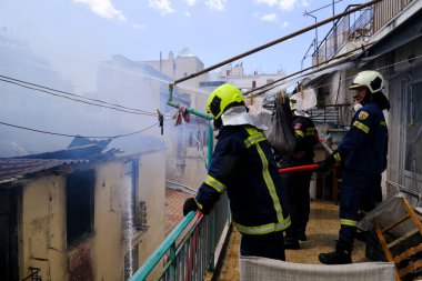 17 Ağustos 2022 'de Atina, Yunanistan' ın merkezindeki terk edilmiş binada yangın söndürmeye çalışan itfaiyeciler görülüyor..