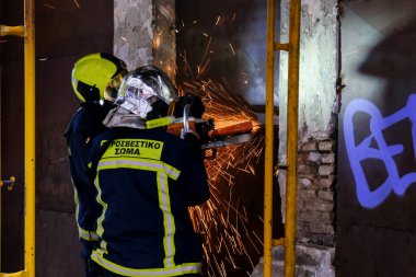 17 Ağustos 2022 'de Atina, Yunanistan' ın merkezindeki terk edilmiş binada yangın söndürmeye çalışan itfaiyeciler görülüyor..