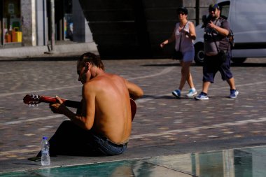 17 Ağustos 2022 'de Atina, Yunanistan' ın merkezinde sıcak bir günde insanlar sokaklarda yürüyor.