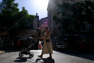 17 Ağustos 2022 'de Atina, Yunanistan' ın merkezinde sıcak bir günde insanlar sokaklarda yürüyor.
