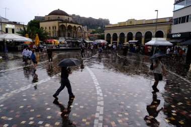 Yunanistan 'ın başkenti Atina' da 23 Ağustos 2022 'de meydana gelen yağış sırasında yayalar kendilerini şemsiyelerle yağmurdan koruyorlar..