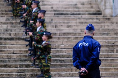 Belçika 'nın Brüksel şehrinde 21 Temmuz 2022' de düzenlenen dini tören sırasında bir polis bölgeyi emniyete aldı..