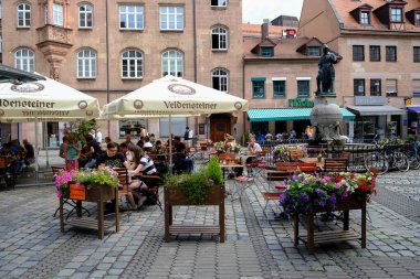 23 Temmuz 2022 'de Almanya' nın Nuremberg kentindeki güneşli bir günde insanlar bir kafenin terasında otururlar..