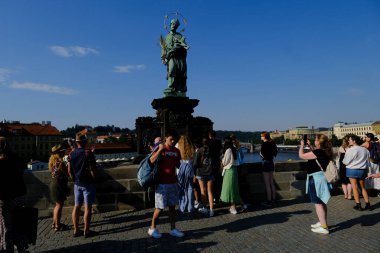 Çek Cumhuriyeti 'nin Prag kentindeki ünlü Charles Köprüsü' nde 27 Temmuz 2022 'de bir grup turist yürüyor..