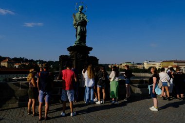 Çek Cumhuriyeti 'nin Prag kentindeki ünlü Charles Köprüsü' nde 27 Temmuz 2022 'de bir grup turist yürüyor..