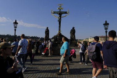 Çek Cumhuriyeti 'nin Prag kentindeki ünlü Charles Köprüsü' nde 27 Temmuz 2022 'de bir grup turist yürüyor..