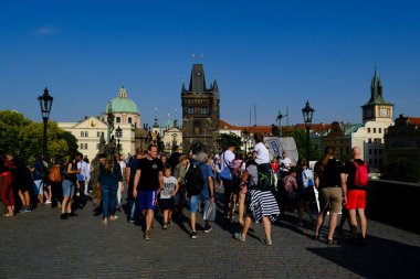 Çek Cumhuriyeti 'nin Prag kentindeki ünlü Charles Köprüsü' nde 27 Temmuz 2022 'de bir grup turist yürüyor..