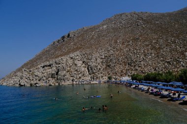 İnsanlar 30 Temmuz 2022 'de Yunanistan' ın Saint Nicholas Plajı 'nda denizin keyfini çıkarıyorlar..