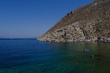 İnsanlar 30 Temmuz 2022 'de Yunanistan' ın Saint Nicholas Plajı 'nda denizin keyfini çıkarıyorlar..