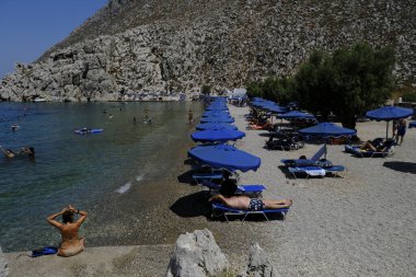 İnsanlar 30 Temmuz 2022 'de Yunanistan' ın Saint Nicholas Plajı 'nda denizin keyfini çıkarıyorlar..