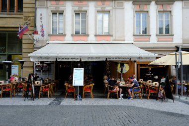 İnsanlar 27 Temmuz 2022 'de Prag, Çek Cumhuriyeti' ndeki kafe terasında güneşli günün tadını çıkarıyorlar..