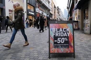 23 Kasım 2022 'de Brüksel, Belçika' da Kara Cuma 'nın önündeki ana alışveriş caddesi Rue Neuve' de satış ve azaltma tabelaları görülüyor..