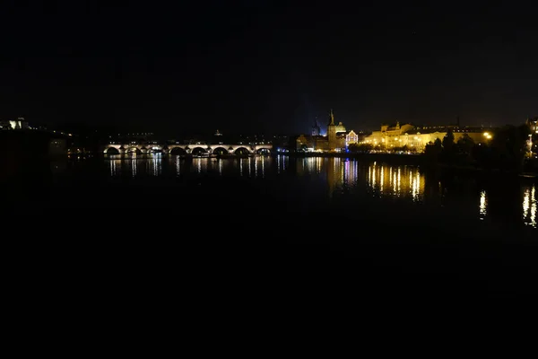 2022年10月7日にチェコ共和国プラハのヴルタヴァ川を渡る中世の石造りのアーチ橋であるカレル橋の夜景 — ストック写真