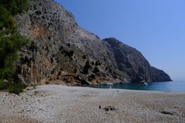 Yunanistan 'ın Symi kentindeki Agios Dimitrios plajında 4 Ağustos 2022' de insanlar güneş ve denizin keyfini çıkarıyorlar..