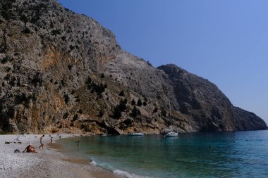 Yunanistan 'ın Symi kentindeki Agios Dimitrios plajında 4 Ağustos 2022' de insanlar güneş ve denizin keyfini çıkarıyorlar..
