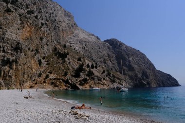 Yunanistan 'ın Symi kentindeki Agios Dimitrios plajında 4 Ağustos 2022' de insanlar güneş ve denizin keyfini çıkarıyorlar..