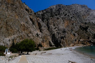 Yunanistan 'ın Symi kentindeki Agios Dimitrios plajında 4 Ağustos 2022' de insanlar güneş ve denizin keyfini çıkarıyorlar..