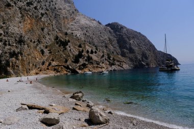 Yunanistan 'ın Symi kentindeki Agios Dimitrios plajında 4 Ağustos 2022' de insanlar güneş ve denizin keyfini çıkarıyorlar..