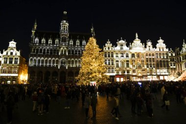 26 Kasım 2022 'de Belçika, Brüksel' de kutlama atmosferinin keyfini çıkaran kimliği belirsiz bir kalabalık ile Grand Place 'te ışıklar ve devasa bir Noel ağacı görülüyor..