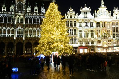 26 Kasım 2022 'de Belçika, Brüksel' de kutlama atmosferinin keyfini çıkaran kimliği belirsiz bir kalabalık ile Grand Place 'te ışıklar ve devasa bir Noel ağacı görülüyor..
