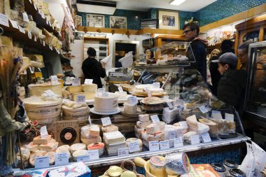 26 Kasım 2022 'de Belçika, Brüksel' deki Delicatessen dükkanında bir tezgahtar peynir ayırıyor..