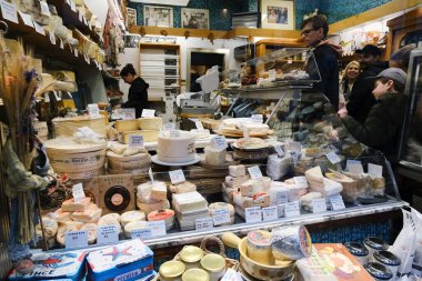 26 Kasım 2022 'de Belçika, Brüksel' deki Delicatessen dükkanında bir tezgahtar peynir ayırıyor..