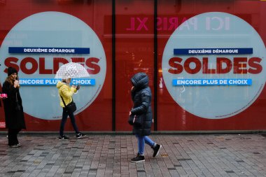 People walk past advertisements of winter sales in Brussels, Belgium, on Jan. 12, 2023. Belgium's 2023 winter sales take place from January 3 to January 31.