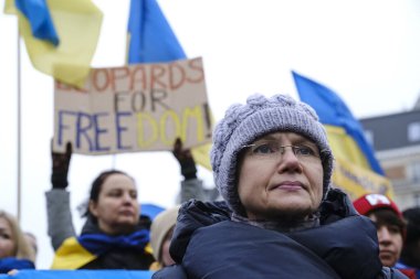 Protestors hold signs and wave Ukrainian flags during a demonstration in support of Ukraine outside of an EU headquarters in Brussels, Belgium , Jan. 23, 2023. 