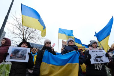 Protestors hold signs and wave Ukrainian flags during a demonstration in support of Ukraine outside of an EU headquarters in Brussels, Belgium , Jan. 23, 2023. 