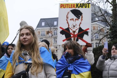 Protestors hold signs and wave Ukrainian flags during a demonstration in support of Ukraine outside of an EU headquarters in Brussels, Belgium , Jan. 23, 2023. 