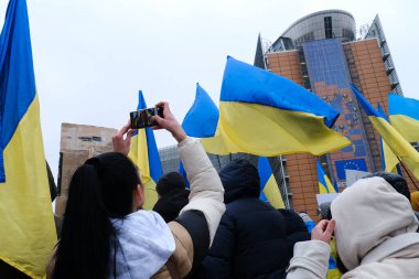 Protestors hold signs and wave Ukrainian flags during a demonstration in support of Ukraine outside of an EU headquarters in Brussels, Belgium , Jan. 23, 2023. 