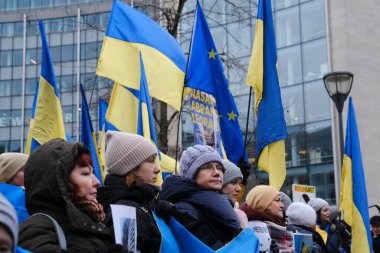 Protestors hold signs and wave Ukrainian flags during a demonstration in support of Ukraine outside of an EU headquarters in Brussels, Belgium , Jan. 23, 2023. 