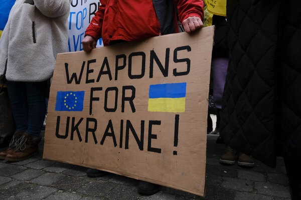 Protestors hold signs and wave Ukrainian flags during a demonstration in support of Ukraine outside of an EU headquarters in Brussels, Belgium , Jan. 23, 2023. 