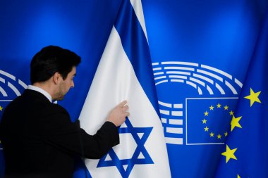 An official prepares the flags of Israle and EU before a meeting at the European Parliament in Brussels, Belgium on January 26, 2023.