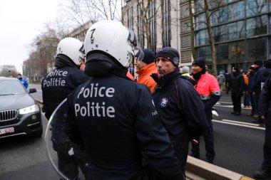 Police officers stand guard as they obstruct the firefighters from blocking the traffic on the road during a protest for better working conditions, in Brussels, Belgium, January 27, 2023.